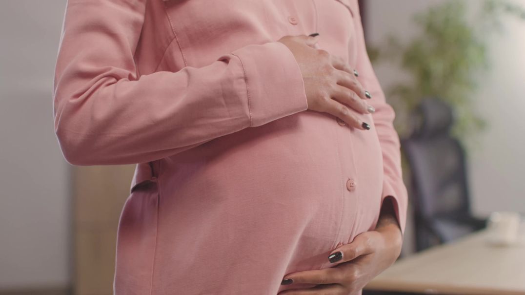 Беременная женщина трогает свой живот
