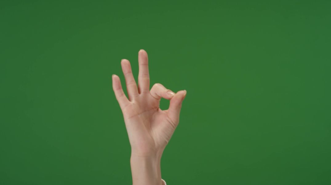 Женская рука делает жест ОКей на зеленом фоне