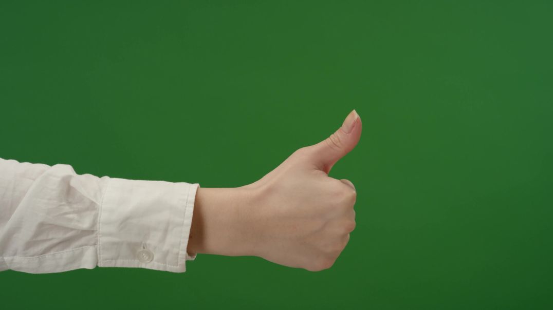 Женская рука делает жест поднятым большим пальцем вверх на зелёном фоне