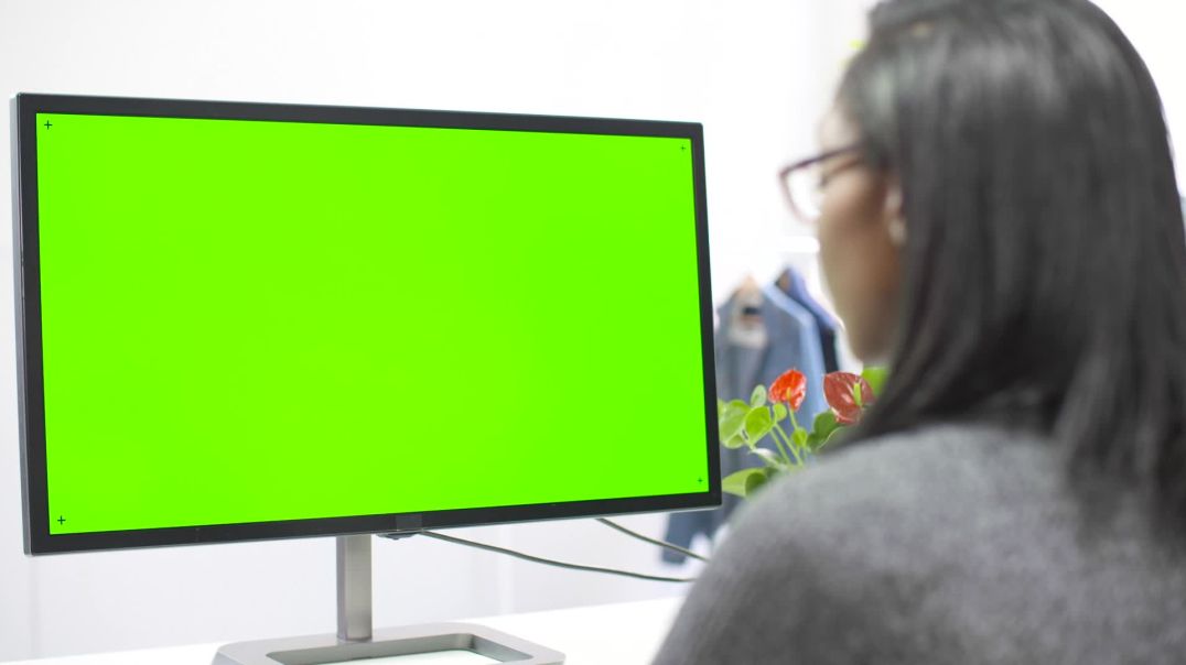 девушка сидит за компьютером, на мониторе зелёный экран