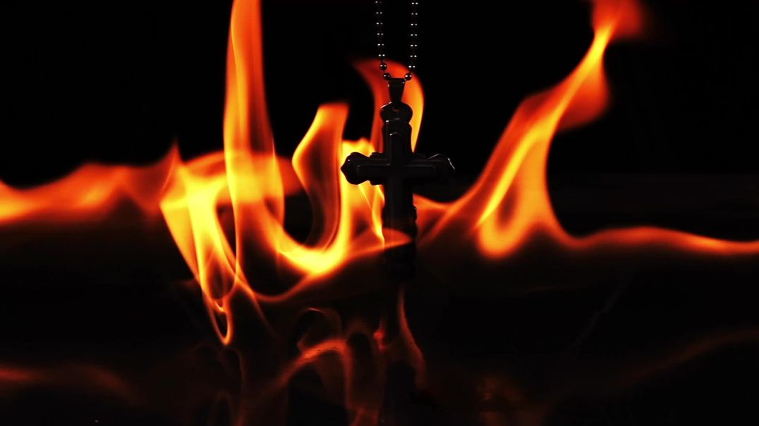 Крест на цепочке в огне на чёрном фоне